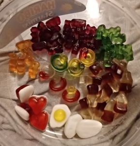 a tub of mixed gummy sweets that have been carefully sorted and separated into their different types